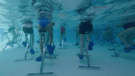 Behind-view-of-women-aqua-biking-in-a-swimming-pool